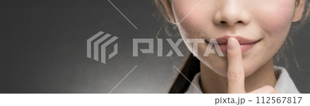 唇に人差し指を当てている東洋人の若い女性 112567817
