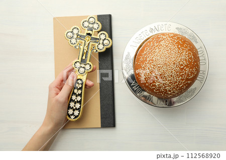 Bread, spikelets, book and cross in hand on white background, top view 112568920