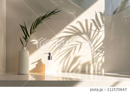 Soothing minimalistic interior decor with sunlight casting a palm leaf shadow 112570647