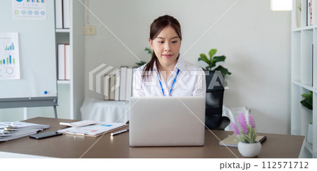Asian business woman using laptop to analysis graph financial budget report and planning for future in office desk Asian business woman using laptop to analysis graph financial budget report and planning for future in office desk 112571712