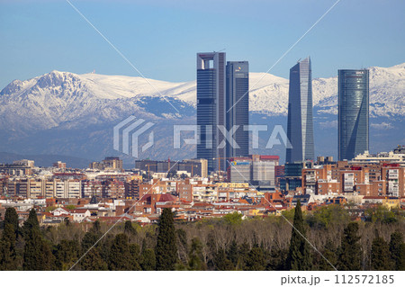 Sierra de Guadarrama. Mountain system seen from the city of Madrid with the recently snow-covered mountains covering the entire top of the mountain range in a white blanket. Skyline next to mountains. Sierra de Guadarrama. Mountain system seen from the city of Madrid with the recently snow-covered mountains covering the entire top of the mountain range in a white blanket. Skyline next to mountains. 112572185