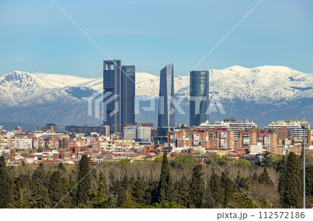 Sierra de Guadarrama. Mountain system seen from the city of Madrid with the recently snow-covered mountains covering the entire top of the mountain range in a white blanket. Skyline next to mountains. Sierra de Guadarrama. Mountain system seen from the city of Madrid with the recently snow-covered mountains covering the entire top of the mountain range in a white blanket. Skyline next to mountains. 112572186