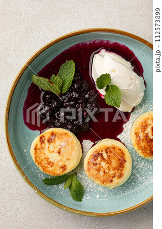 Russian cottage cheese syrniki with berries and cream Russian cottage cheese syrniki with berries and cream 112573899
