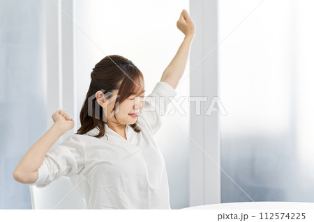 部屋で伸びをする女性 部屋で伸びをする女性 112574225