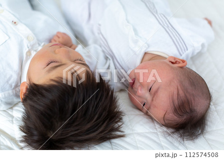 昼寝をする幼児と乳児ふたり 112574508