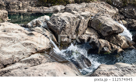 Crystalline waters cascade over rugged rocks into serene pools at the Isle of Skye's Fairy Pools Crystalline waters cascade over rugged rocks into serene pools at the Isle of Skye's Fairy Pools 112574945