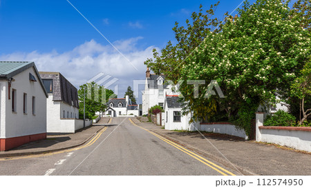 White-rendered houses of Ullapool among vibrant foliage and blossoms, beneath Scotland's blue skies White-rendered houses of Ullapool among vibrant foliage and blossoms, beneath Scotland's blue skies 112574950