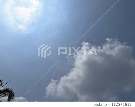 Heavenly white clouds on the blue sky with the sun appeared 112575615