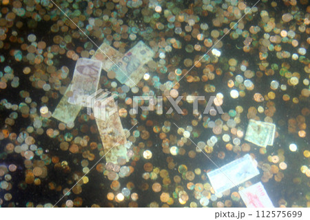 Coins and banknotes at bottom of a wishing well 112575699