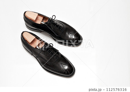 綺麗に磨いた黒いフルブローグの英国製革靴 112576316