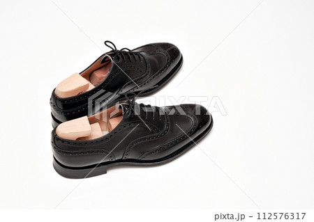 綺麗に磨いた黒いフルブローグの英国製革靴 112576317