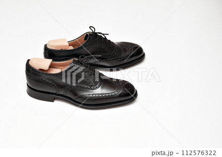 綺麗に磨いた黒いフルブローグの英国製革靴 112576322