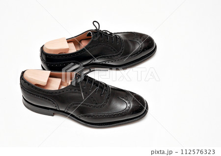 綺麗に磨いた黒いフルブローグの英国製革靴 112576323