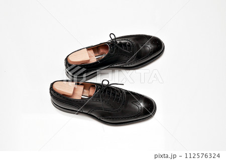 綺麗に磨いた黒いフルブローグの英国製革靴 112576324