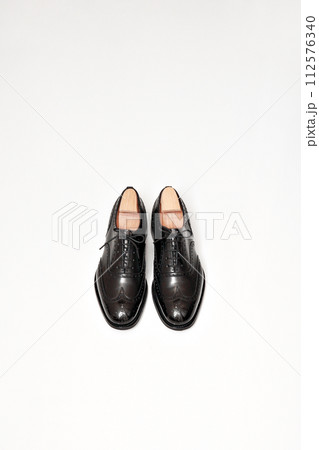 綺麗に磨いた黒いフルブローグの英国製革靴 112576340