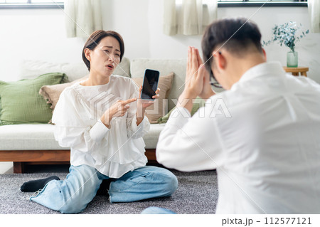 スマホを見て怒る女性 112577121