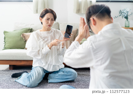 スマホを見て怒る女性 112577123