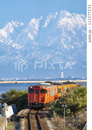 道の駅雨晴から氷見線の列車と立山連峰 112577231