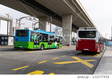 Electric bus at a stop is charged by pantograph. Clean mobility 112577458