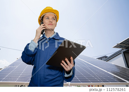 Woman with digital tablet on a background of mobile solar power station.. 112578261