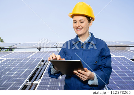 Woman with digital tablet on a background of mobile solar power station.. Woman with digital tablet on a background of mobile solar power station.. 112578266