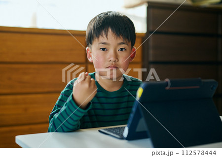 タブレットでタイピングの練習をする小学生の男の子 112578444
