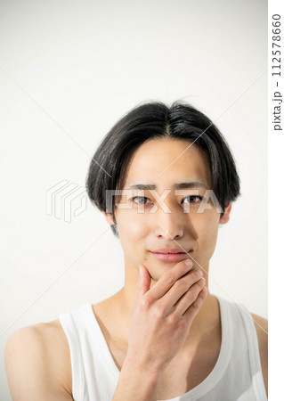 白バックで顔に手を添える若い男性 白バックで顔に手を添える若い男性 112578660
