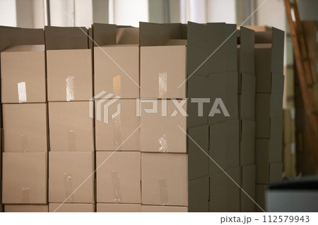 Lots of cardboard boxes stacked in rows. 112579943