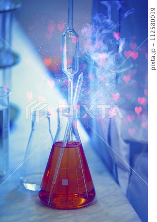 Glass laboratory flasks with chemical substance and magic glow. Making a magical love potion for fortune telling. 112580019