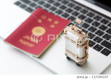旅行バックのトランクケースとパソコンとパスポート 112580107