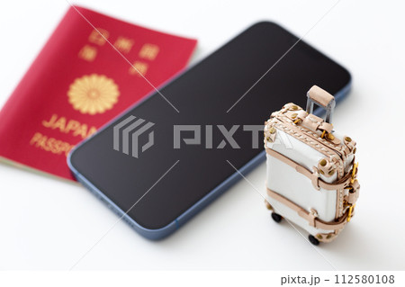 旅行バックのトランクケースとスマホとパスポート 112580108