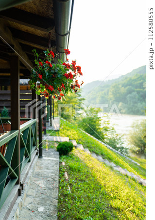 Porch of a wooden house in the forest on the river bank Porch of a wooden house in the forest on the river bank 112580555
