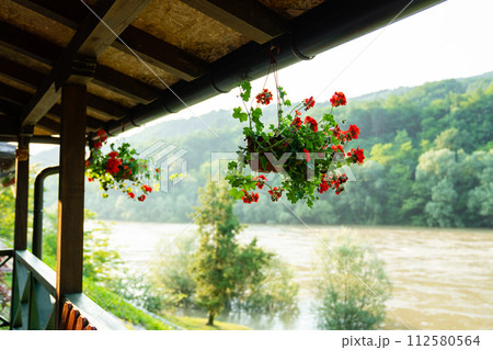Porch of a wooden house in the forest on the river bank 112580564