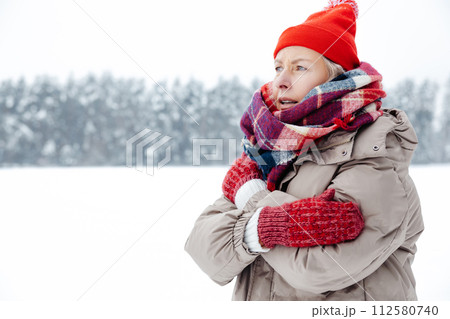 Woman red hat and checkered scarf feeling cold and shivering 112580740