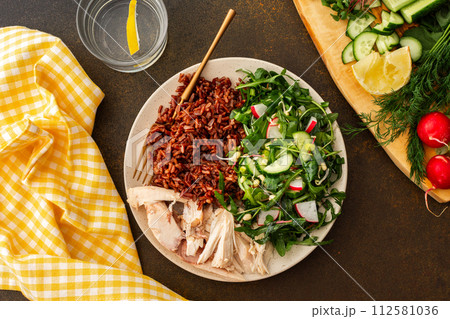 Chicken breast with red rice and salad mix with seasonal organic vegetables 112581036