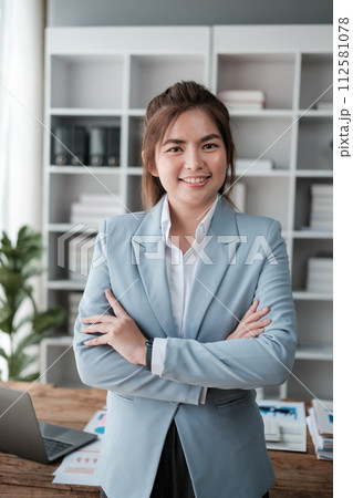Portrait of a successful and happy businesswoman in her office, an office worker smiling and looking at the camera with crossed arms, working inside a modern office. Portrait of a successful and happy businesswoman in her office, an office worker smiling and looking at the camera with crossed arms, working inside a modern office. 112581078