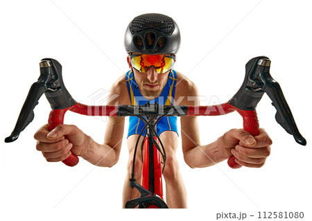 Concentrated male cyclist in blue uniform, helmet and protective goggles riding on bike isolated on white studio background 112581080