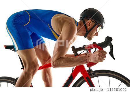 Competitive young man in blue uniform training, riding bicycle, developing speed isolated on white studio background 112581092