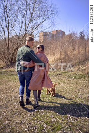 a stylish young couple walking with their dog in nature a stylish young couple walking with their dog in nature 112581261