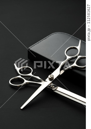 Hairdressing scissors with case on a black background Hairdressing scissors with case on a black background 112581627