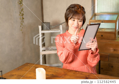 カフェでメニューを選ぶ女性　 112582445