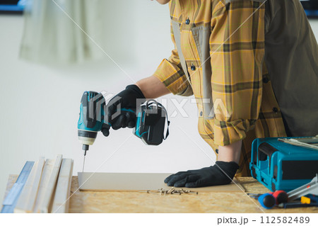 電動ドライバーで作業する若い男性 電動ドライバーで作業する若い男性 112582489