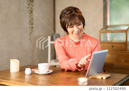 カフェでメニューを選ぶ女性　 112582490