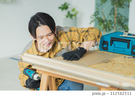 電動ドライバーで作業する若い男性 112582511