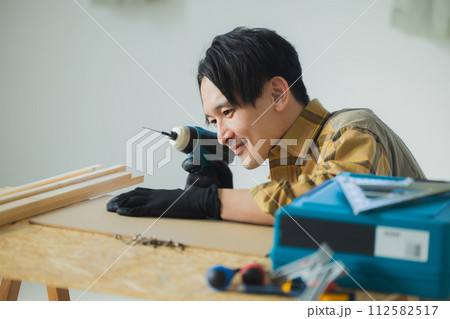 電動ドライバーで作業する若い男性 112582517
