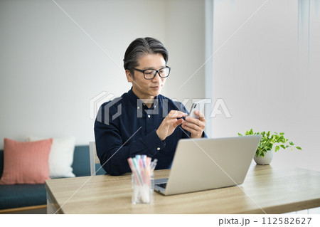 リビングでテレワークをするミドル男性 112582627