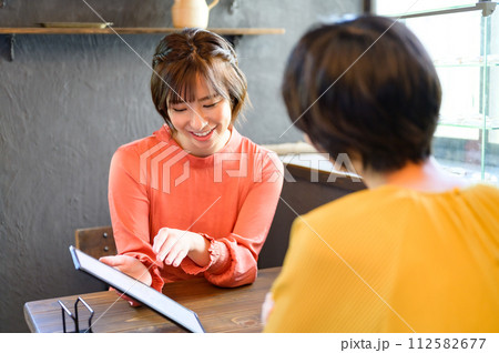 カフェでメニューを選ぶ二人の女性 カフェでメニューを選ぶ二人の女性 112582677