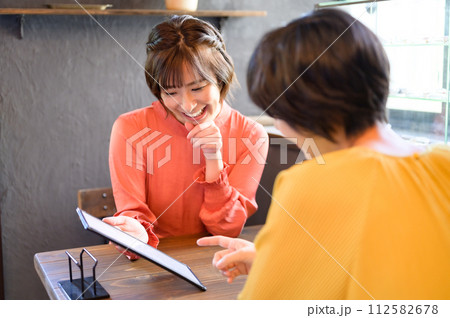カフェでメニューを選ぶ二人の女性　 112582678