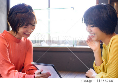 カフェでメニューを選ぶ二人の女性 カフェでメニューを選ぶ二人の女性 112582681