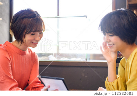 カフェでメニューを選ぶ二人の女性　 112582683